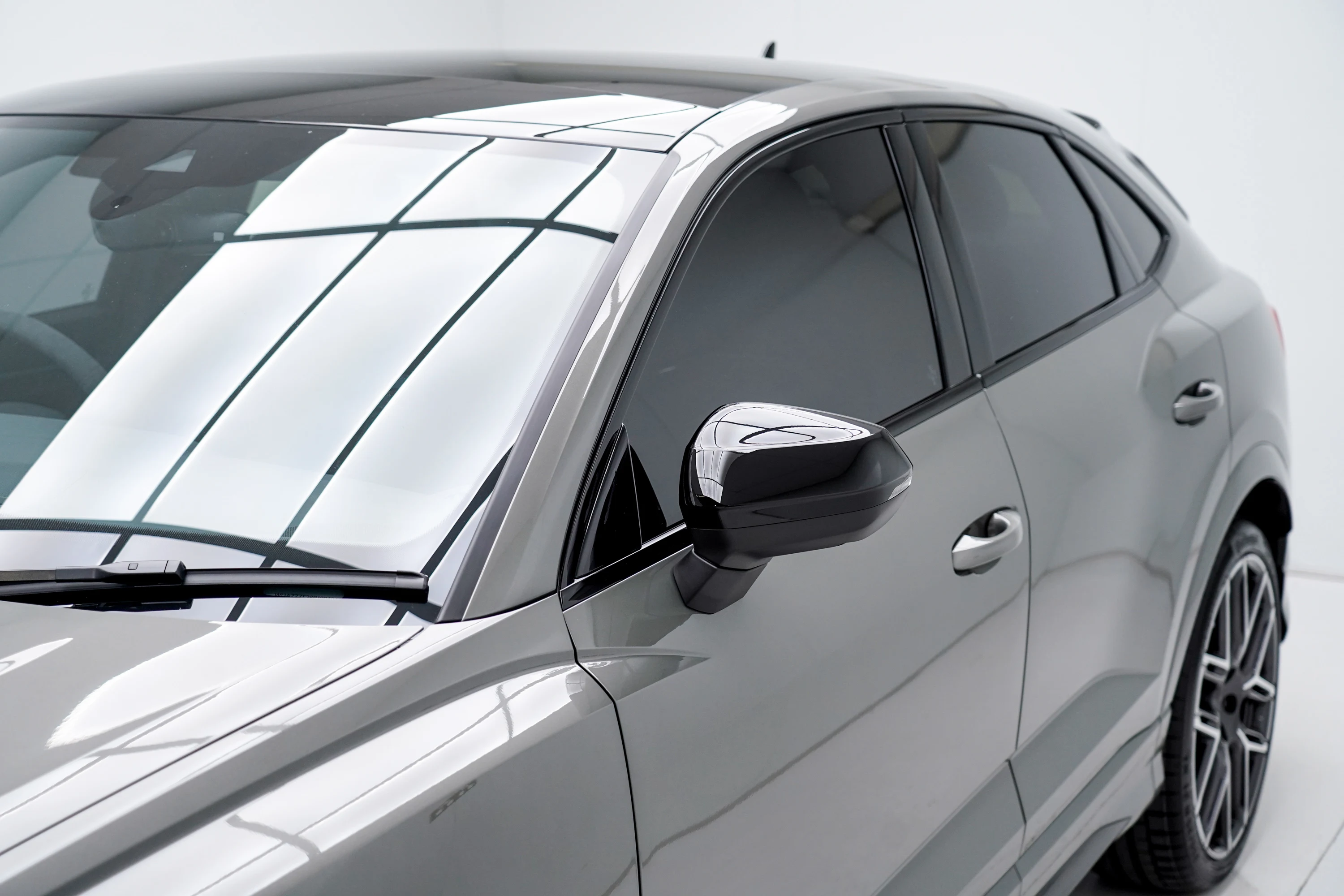 Side mirror and front door of a silver SUV in the OCD workshop